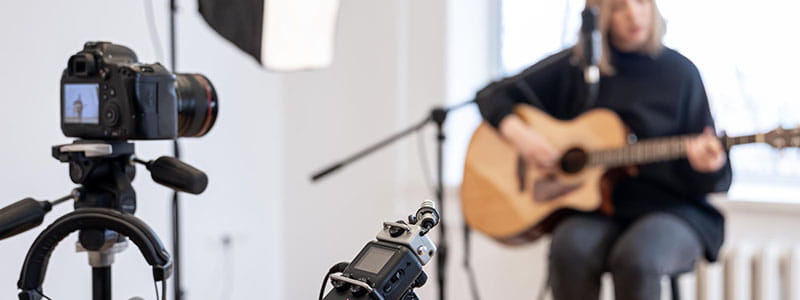 Guitariste devant un micro et un appareil photo